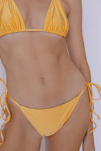 Close-up on Sinclair Bikini Bottom in Shimmer Naples Yellow by Ozero Swimwear, front view, designed in Malaysia.