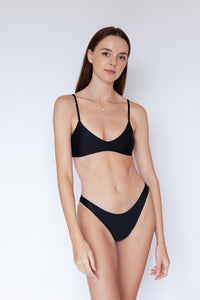 Model wearing Como sustainable Bikini Bottom in Black by Ozero Swimwear, front view, designed in Malaysia.