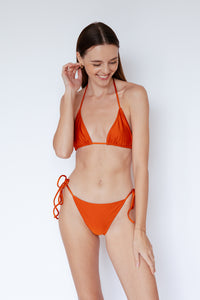 Model wearing Sinclair Bikini Bottom in Shimmer Burnt Orange by Ozero Swimwear, front view, designed in Malaysia.