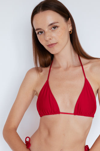 Close-up on model wearing Sinclair Bikini Top in Shimmer Ruby Red by Ozero Swimwear, front view, designed in Malaysia.